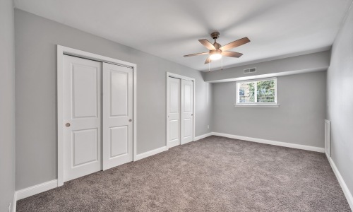 a bedroom with carpet and a fan
